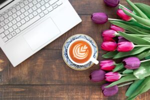 パソコンとチューリップとコーヒーの画像